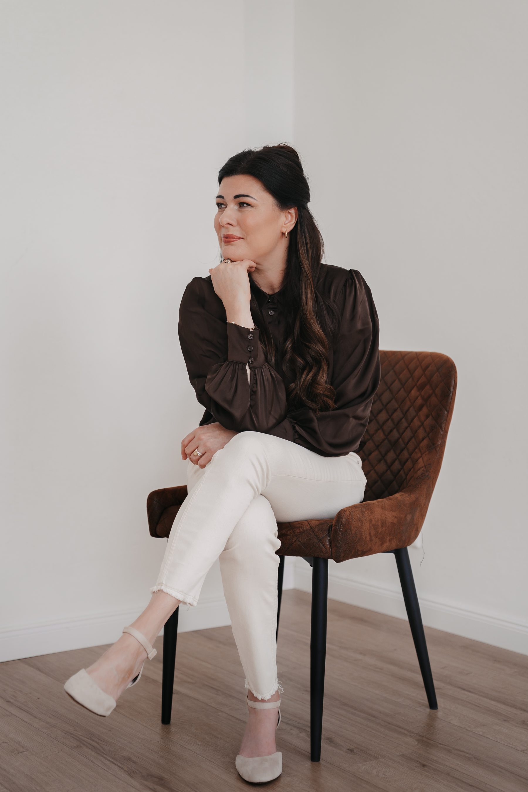 Julia Horneber, sitzend und nachdenklich im Porträt