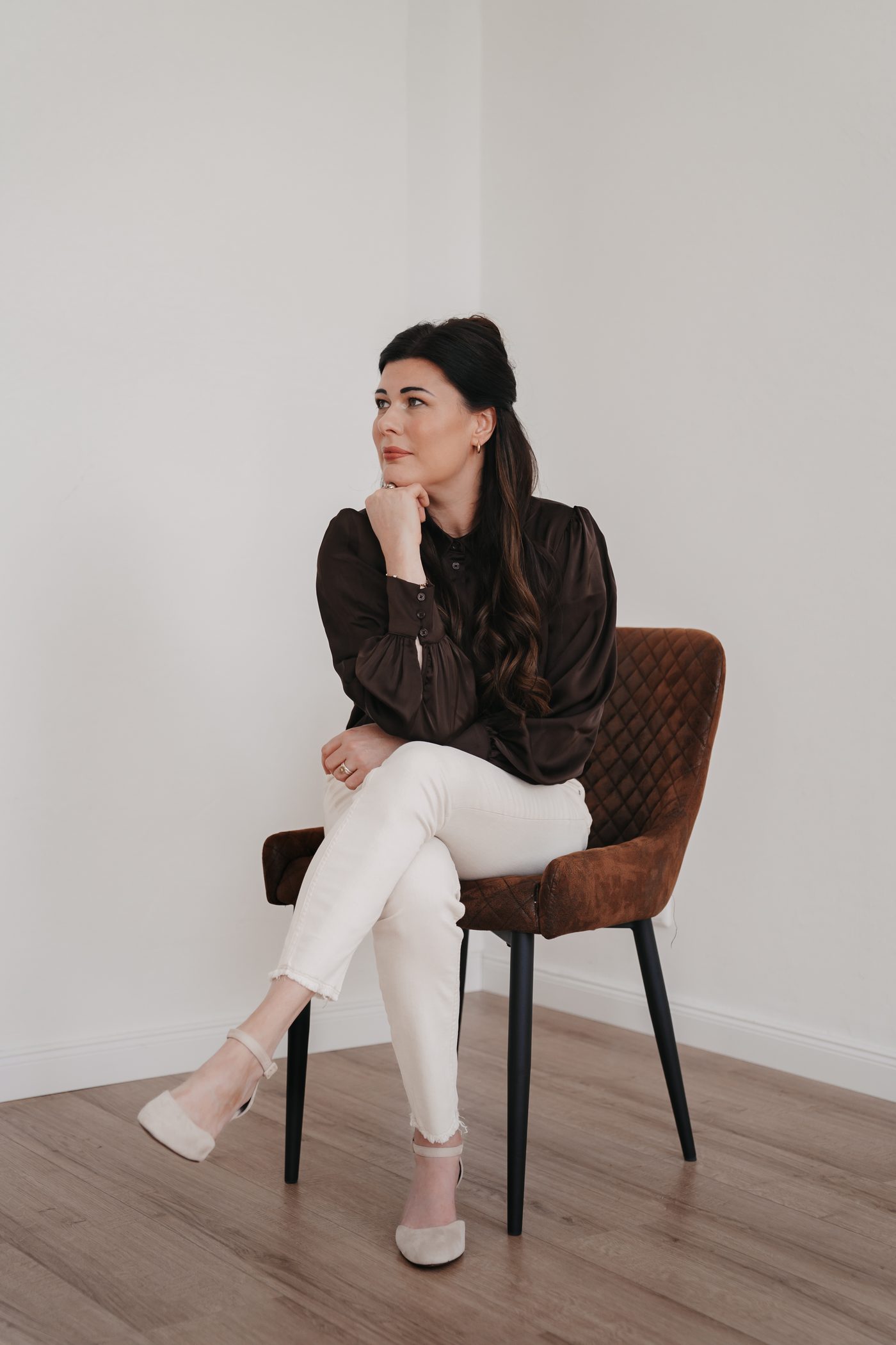 Julia Horneber, sitzend mit Hand am Kinn
